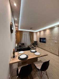 ein Wohnzimmer mit Tisch, Stühlen und Sofa in der Unterkunft Hil Obrenovac in Obrenovac