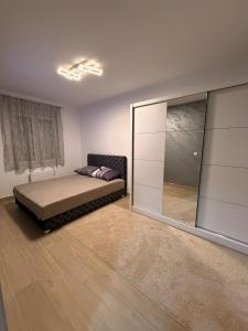 ein Schlafzimmer mit einem Bett und einem großen Spiegel in der Unterkunft Hil Obrenovac in Obrenovac + 3 Fotos