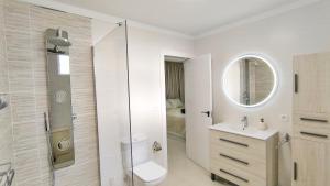 a bathroom with a toilet and a sink and a mirror at HEI HEI AND PUA VILLA - heated pool, priv parking, fibre net, Palm-Mar in Palm-Mar +36 photos