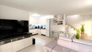 a living room with a couch and a large television at HEI HEI AND PUA VILLA - heated pool, priv parking, fibre net, Palm-Mar in Palm-Mar