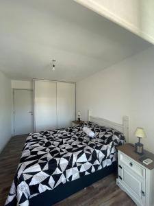 a bedroom with a black and white comforter on a bed at Hermoso apartamento en Buceo! in Montevideo