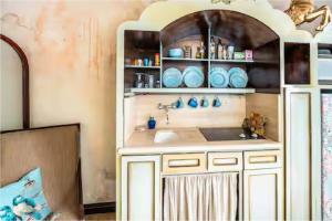 - une cuisine avec un évier et une étagère avec de la vaisselle dans l'établissement Casa Lucienne, à San Juan