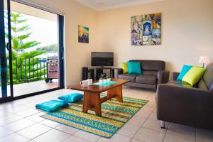 a living room with a table and a couch at Cottesloe Sea Bliss Apartment in Perth