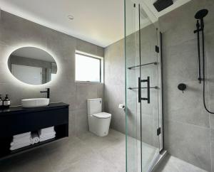a bathroom with a toilet and a glass shower at Avero in Rotorua +87 photos