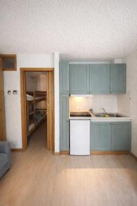 an empty kitchen with blue cabinets in a room at Lo Gnomo Apartment in Marilleva