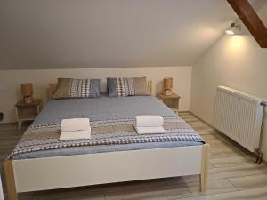 een slaapkamer met een groot bed met twee kussens erop bij Riverside in Valjevo