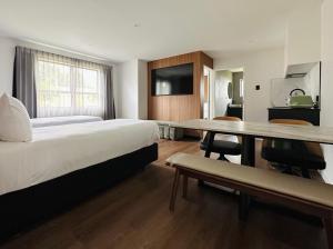 a hotel room with a large bed and a table at Avero in Rotorua