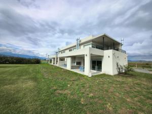 een groot wit huis op een grasveld bij LS Apart Hotel in Martin Miguel de Güemes International Airport