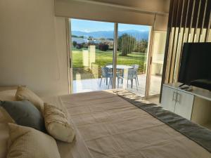 ein Schlafzimmer mit Bett und ein Balkon mit Tisch in der Unterkunft LS Apart Hotel in Martin Miguel de Güemes International Airport
