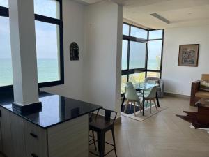 a living room with a table and chairs and windows at Villa Regia in Poponguine