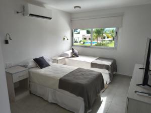 ein Hotelzimmer mit zwei Betten und einem Fenster in der Unterkunft LS Apart Hotel in Martin Miguel de Güemes International Airport + 29 Fotos