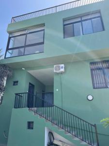a blue building with a staircase and a window at Villa Regia in Poponguine