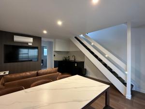 a living room with a couch and a staircase at Avero in Rotorua