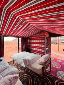 a bedroom with two beds in a tent in the desert at Wadi Rum Trip in Wadi Rum