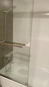 een glazen douchedeur in de badkamer bij Departamentos en Edificio Distrito Cavancha 1 in El Cerrillo