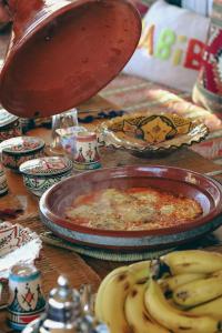 a table with a plate of food and some bananas at Mabidi Surf Taghazout in Taghazout