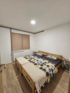 ein Schlafzimmer mit zwei Betten und einem großen Fenster in der Unterkunft Casa bianca Pale in Pale