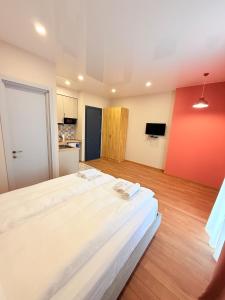 a large bed in a room with a red wall at Cosy City-View Flat in Mtatsminda, flat 6 in Itʼkhvisi