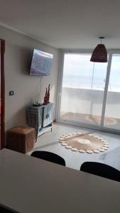 een woonkamer met uitzicht op de oceaan bij Departamentos en Edificio Distrito Cavancha 1 in El Cerrillo