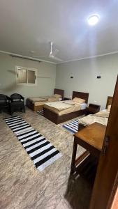 een kamer met meerdere bedden en een kamer met vloerkleden bij Nuba Nest in Aswan