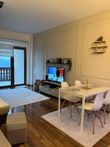 een woonkamer met een tafel en stoelen en een televisie bij Nirvana Lux Apartman Zlatar in Brdo +26 foto's