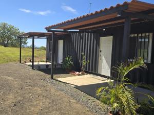 a black house with a porch and a white door at Santa Catalina Surf Studios- Ocean Adventures in Santa Catalina