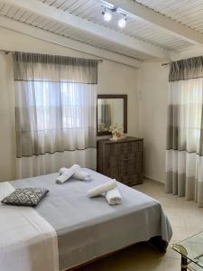 une chambre avec un grand lit avec des serviettes dessus dans l'établissement vasiliki's Apartments, à Dhímitra