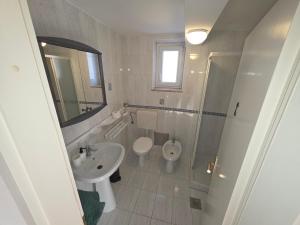 a bathroom with a sink and a toilet and a shower at Apartmaji Trije Valovi in Piran +36 photos