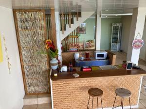 eine Küche mit einer Theke und 2 Hockern in einem Zimmer in der Unterkunft Tahiti Pacific Lodge Punaauia in Punaauia