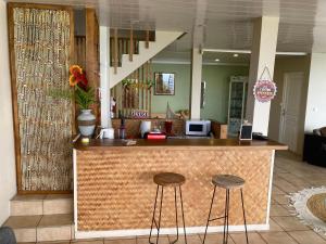 eine Theke in einem Zimmer mit zwei Hockern in der Unterkunft Tahiti Pacific Lodge Punaauia in Punaauia