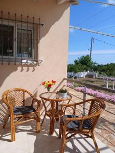 d'une terrasse avec 2 chaises, une table et une fenêtre. dans l'établissement vasiliki's Apartments, à Dhímitra 16 autres photos