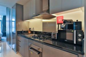 eine Küche mit einem Kochfeld und einer Mikrowelle in der Unterkunft Damac Maison Prive Deluxe Studio with Water Canal View in Dubai