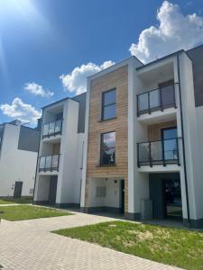 a modern house with a blue sky at Słoneczny Apartament Karpicko in Karpicko