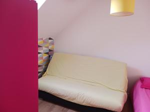 een witte bank in een kamer met een roze muur bij Lila in Souillé