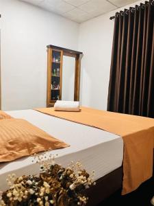 a bedroom with two beds and a table with flowers on it at location weligama in Weligama +6 photos