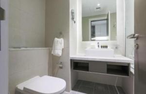 ein weißes Badezimmer mit Waschbecken und Toilette in der Unterkunft Damac Maison Prive Deluxe Studio with Water Canal View in Dubai