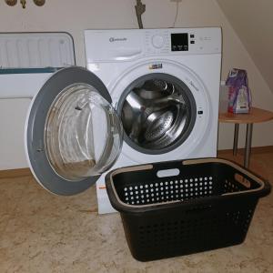een wasmachine met een mand ervoor bij Urban Apple in Bad Mergentheim
