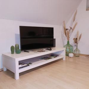 een wit entertainmentcentrum met een flatscreen-tv erop bij Urban Apple in Bad Mergentheim