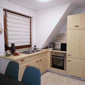 een keuken met houten kasten, een wastafel en een raam bij Urban Apple in Bad Mergentheim +10 foto's