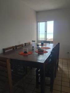 a large wooden table with chairs in a room at Apartamento BEIRA MAR - Edifício Mar Del Plata in Itamaracá