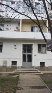 een wit gebouw met een deur ervoor bij Signorina in Sajmište +1 foto