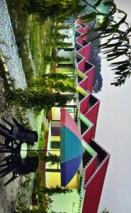 a reflection of a building with an umbrella in the water at Pine Apple Resorts in Jalpāiguri