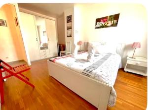 una camera da letto con un grande letto bianco in una stanza di MaisonTevy - Appart & Studio pro-tourisme a Pontault-Combault