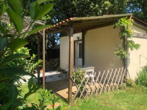 eine hölzerne Pergola mit einem Stuhl im Hof in der Unterkunft les écureuils in Veyrines-de-Vergt