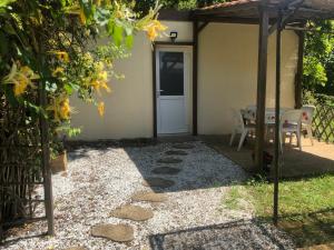 eine Terrasse mit einem Tisch, Stühlen und einer Tür in der Unterkunft les écureuils in Veyrines-de-Vergt