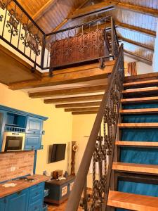 a spiral staircase in a kitchen with blue cabinets at A-Termal Palić in Palić