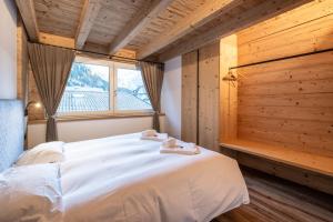 a bedroom with a large white bed with a window at - Piz Boe - Canazei center app. in Canazei