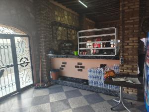 a room with a door and a shelf with bottles of water at Hotel El Golla in Er Rachidia +17 photos