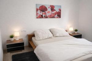 een slaapkamer met een bed met twee nachtkastjes en twee lampen bij Maisonette am Burg in Möckmühl