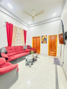 a living room with a red couch and a table at MSGuest House in Jaffna